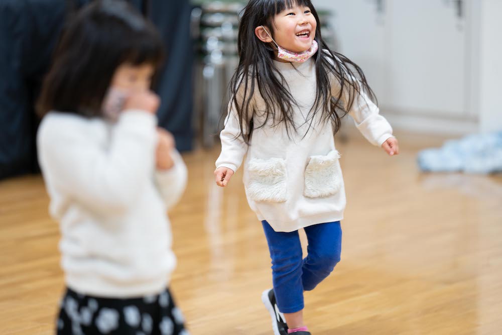 二人の女の子が笑顔で踊っている様子